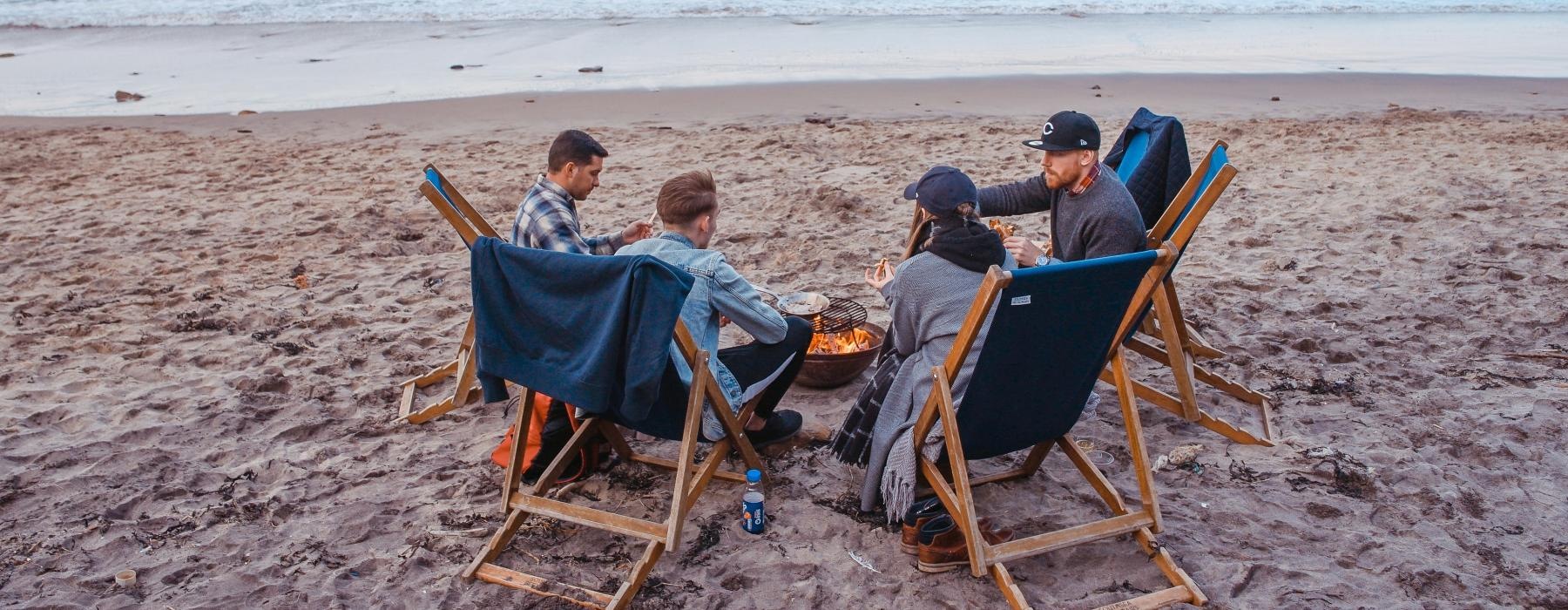 a group of people sitting in chairs on a beach