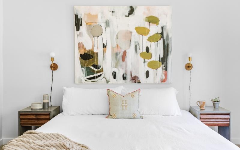 a bed with a painting on the wall