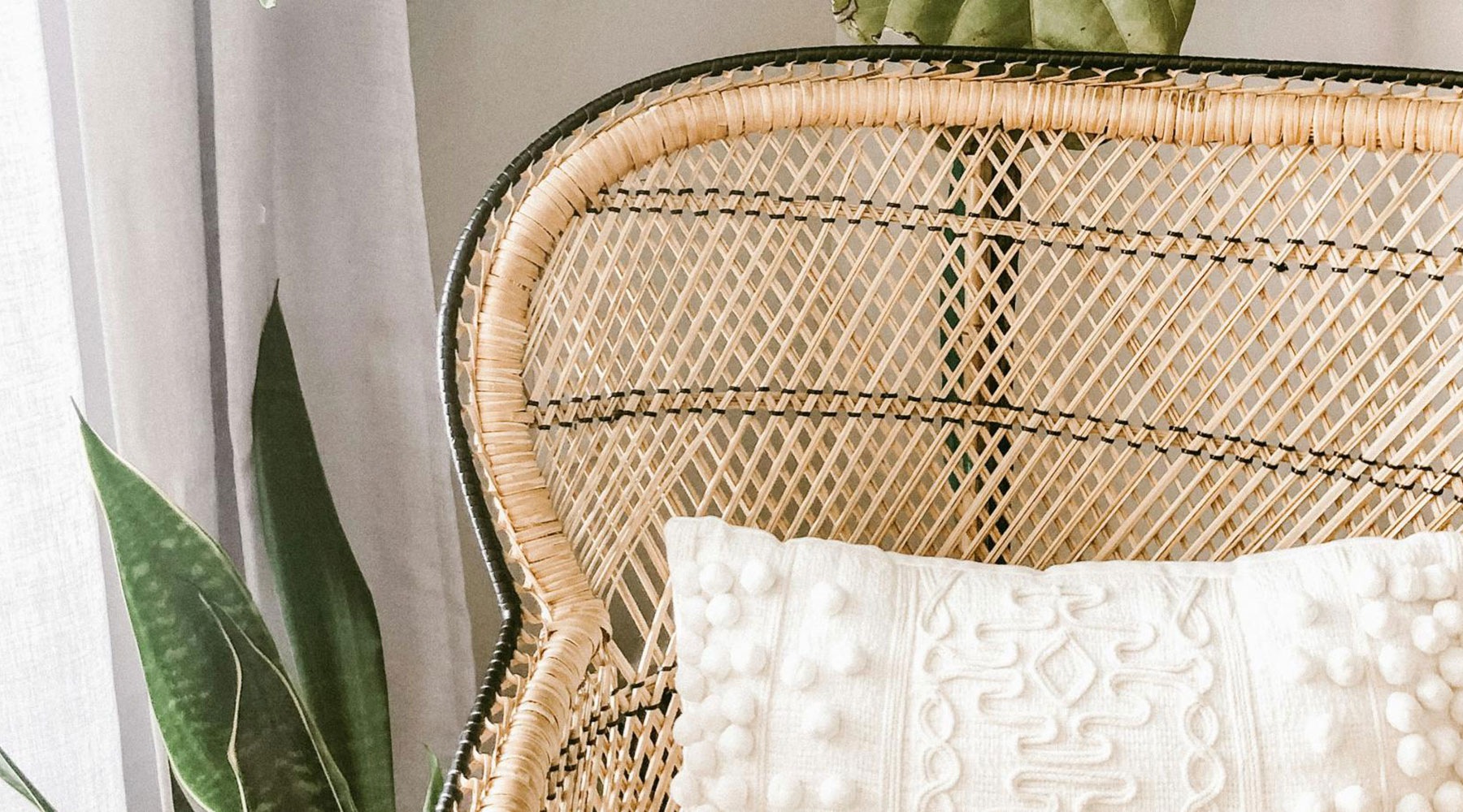 Beautiful living areas to match your lifestyle wooden chair with white pillows and plants in the back in front of a white wall.